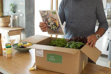 Woman opening a box of food from a meal delivery service