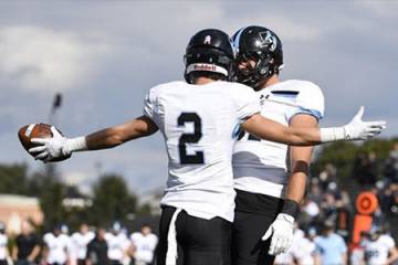 Two Johns Hopkins football players celebrate a touchdown