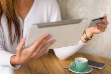 Woman entering credit card information into tablet