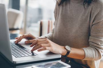 A woman's hands on a computer keyboard