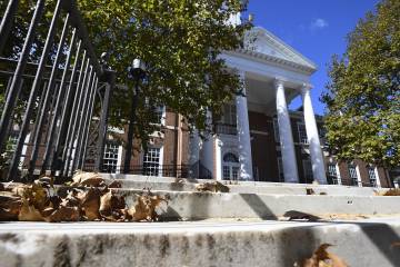 Exterior of Gilman Hall with fall leaves on the marble steps
