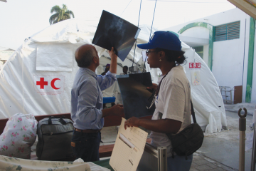 Emergency personnel review X-rays without electric viewing screens at Haiti's University Hospital one month after the earthquake