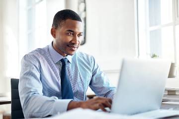 Man in office looking at laptop screen