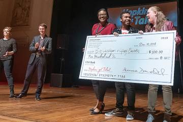 Winners Greg Burks and Eve Carlson receive a check from Jayde Antonio