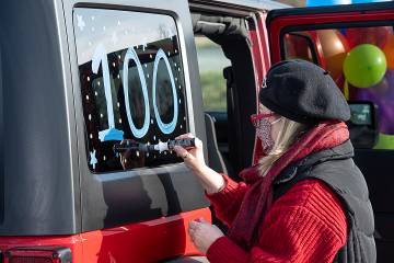 Woman painting 100 on car window