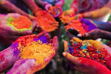 Hands holding colorful powder for Holi celebration