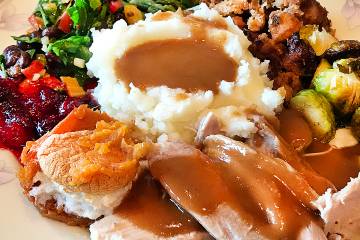 A dinner plate filled with turkey and side dishes