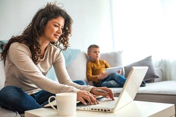  CAPTION: Woman working at home with her young son nearby