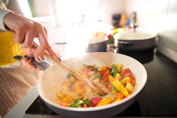 Close-up on vegetables cooking in a skillet