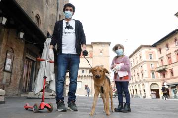A father and daughter walk their dog in Italy
