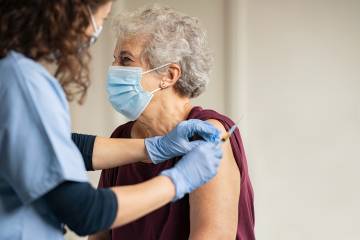 A vaccine is administered to an older woman