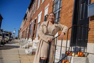 Carleigh Steele outside her new home in the Milton-Montford community. It is a brown brick rowhouse with marble steps.