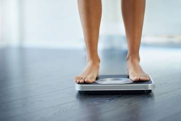 Lower part of a woman's legs standing on a scale