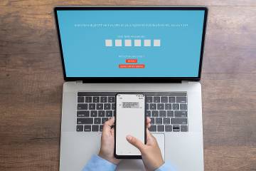 Person receiving code on cellphone in order to enter it on computer for access to an online account 