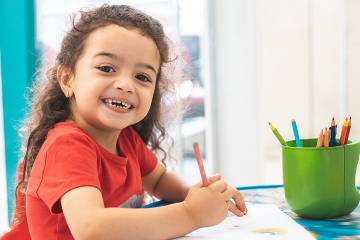 Young girl drawing with colored pencils