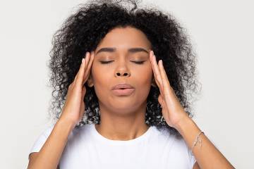 Stressed-out woman with hands on temples