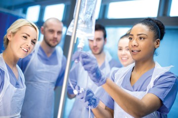 Five nurses adjust a saline drip
