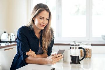 Woman at kitchen island using an app on her phone