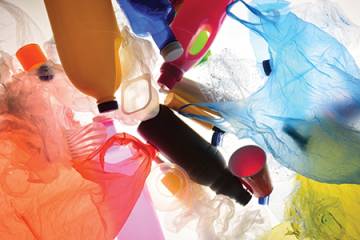 A pile of plastic products, including bottles, cups, and plastic bags