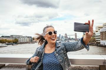 Happy senior woman taking a selfie in a foreign country