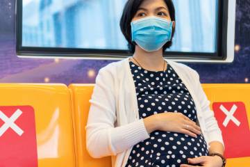 A pregnant woman rides public transit