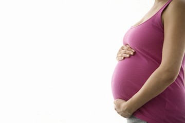 A pregnant woman holds her belly