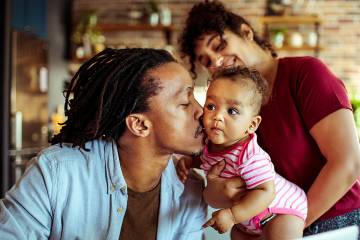 Young man kissing his baby