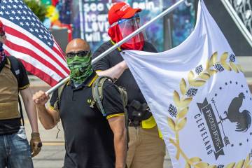 Pro-Trump protesters wear masks, military-style gear, and one carries a handgun