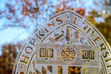 JHU seal with fall leaves in the background
