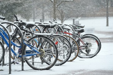 Bikes lines up in a bike rack in the snow