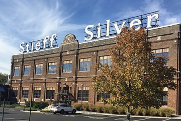 Exterior of the Stieff Silver building depicts a brick building topped with a giant Stieff Silver sign