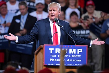 Donald Trump shrugs at podium at Phoenix rally