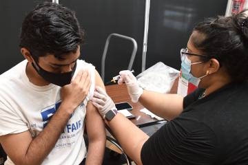 A student gets vaccinated at a free Johns Hopkins vaccine clinic