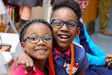 Two little girls smile in brand new glasses 