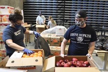 Volunteers pack food into boxes for families of Henderson-Hopkins students