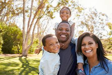 Smiling man and woman with two young children