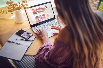 Woman working on laptop at her kitchen table