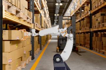 A robot in a wharehouse reaching for boxes