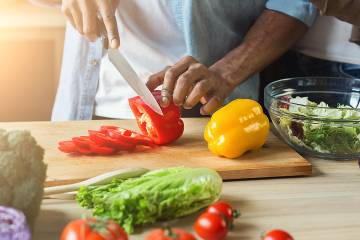 Closeup of man's hands preparing salad