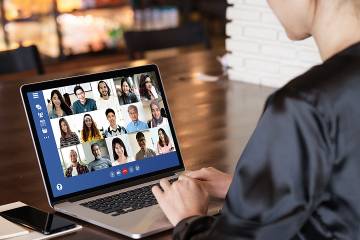 Woman on laptop whose screen shows event participants.