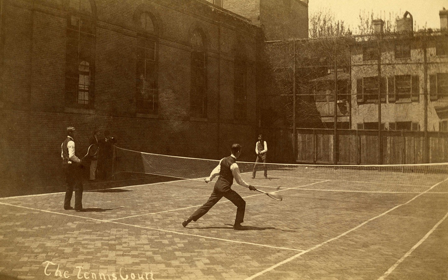 Men in suit vests play tennis