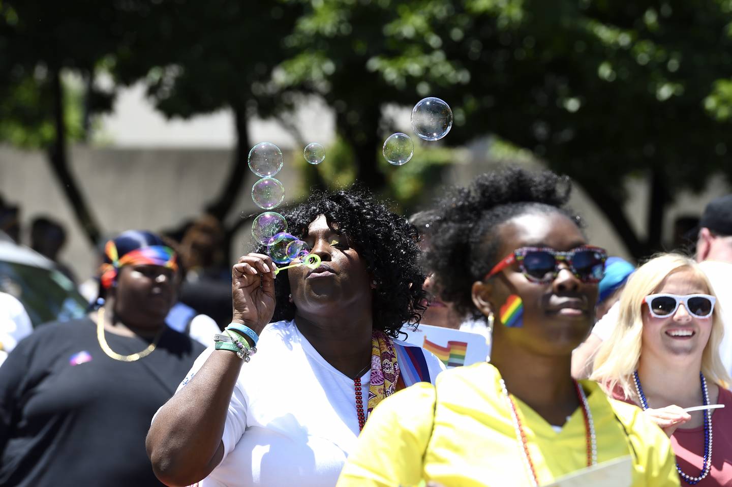 A woman blows bubbles at Pride