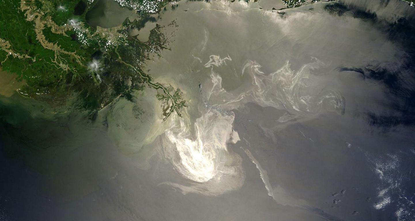 A satellite image shows a large reflective oil slick in the Gulf of Mexico as well as nearby coastline
