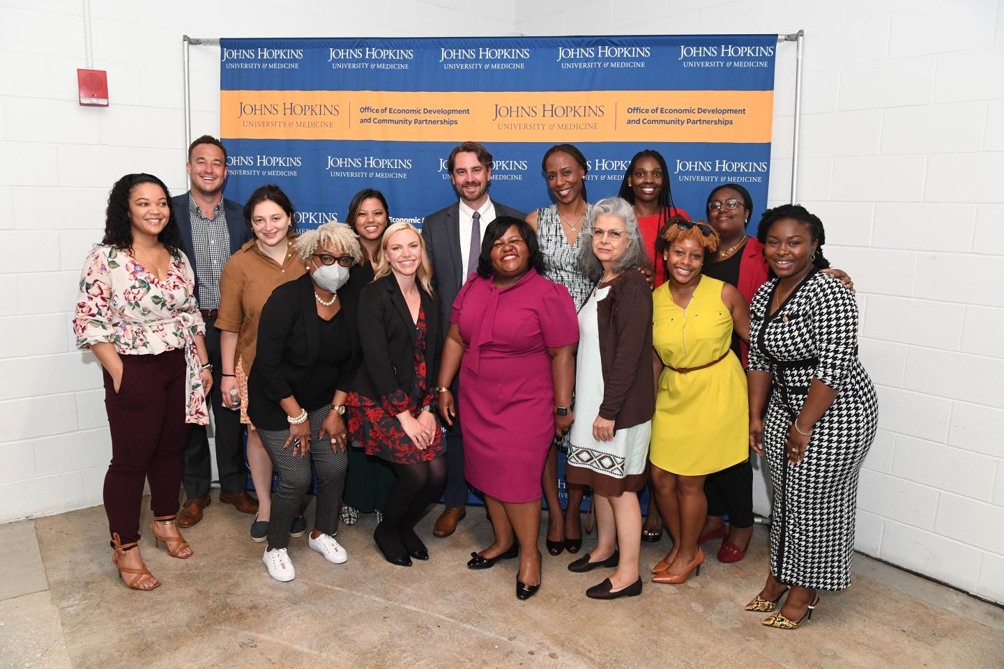 A group photo of people in front of a banner for HopkinsLocal