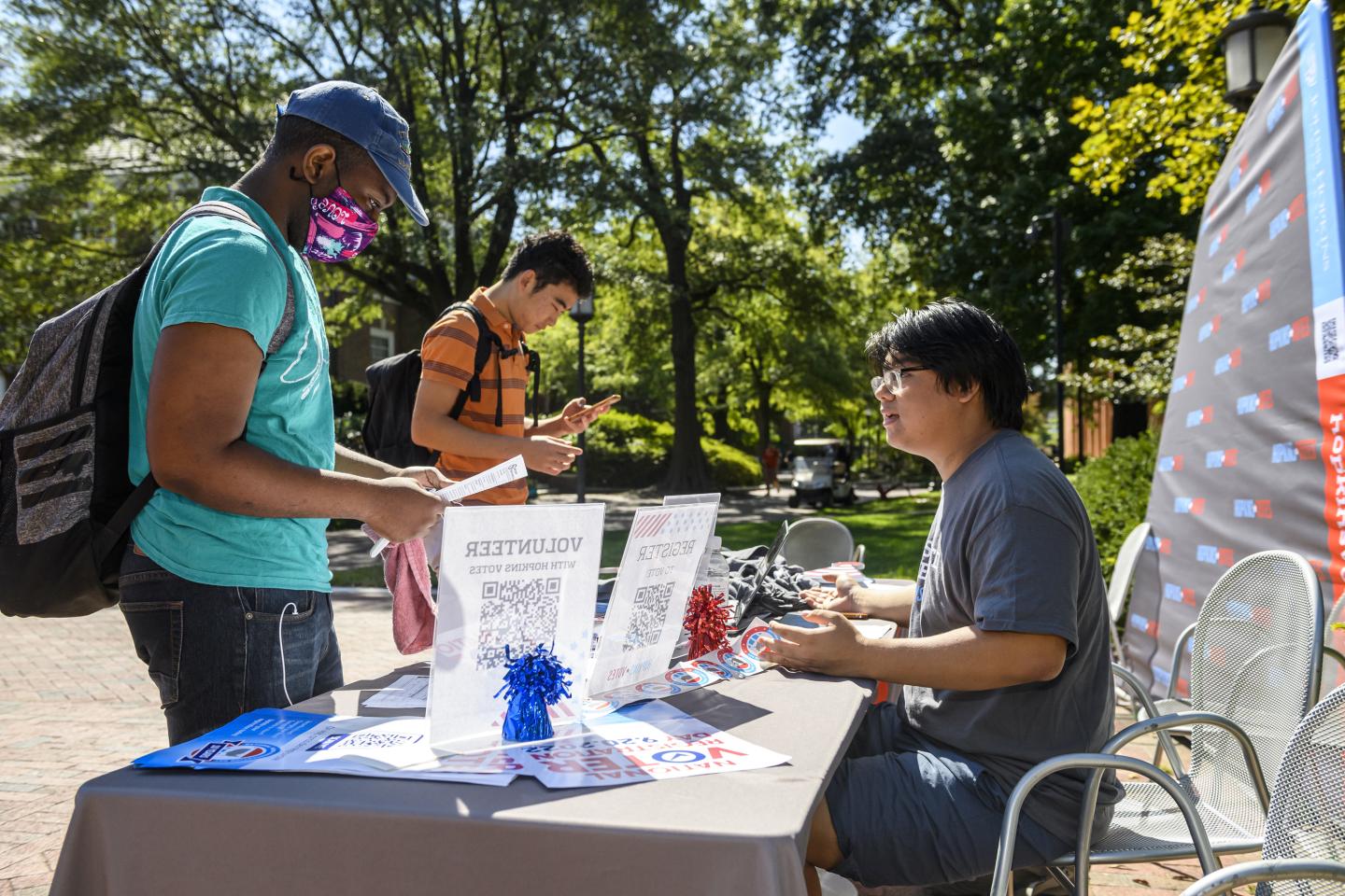 A Hopkins Votes volunteer helps a student register to vote