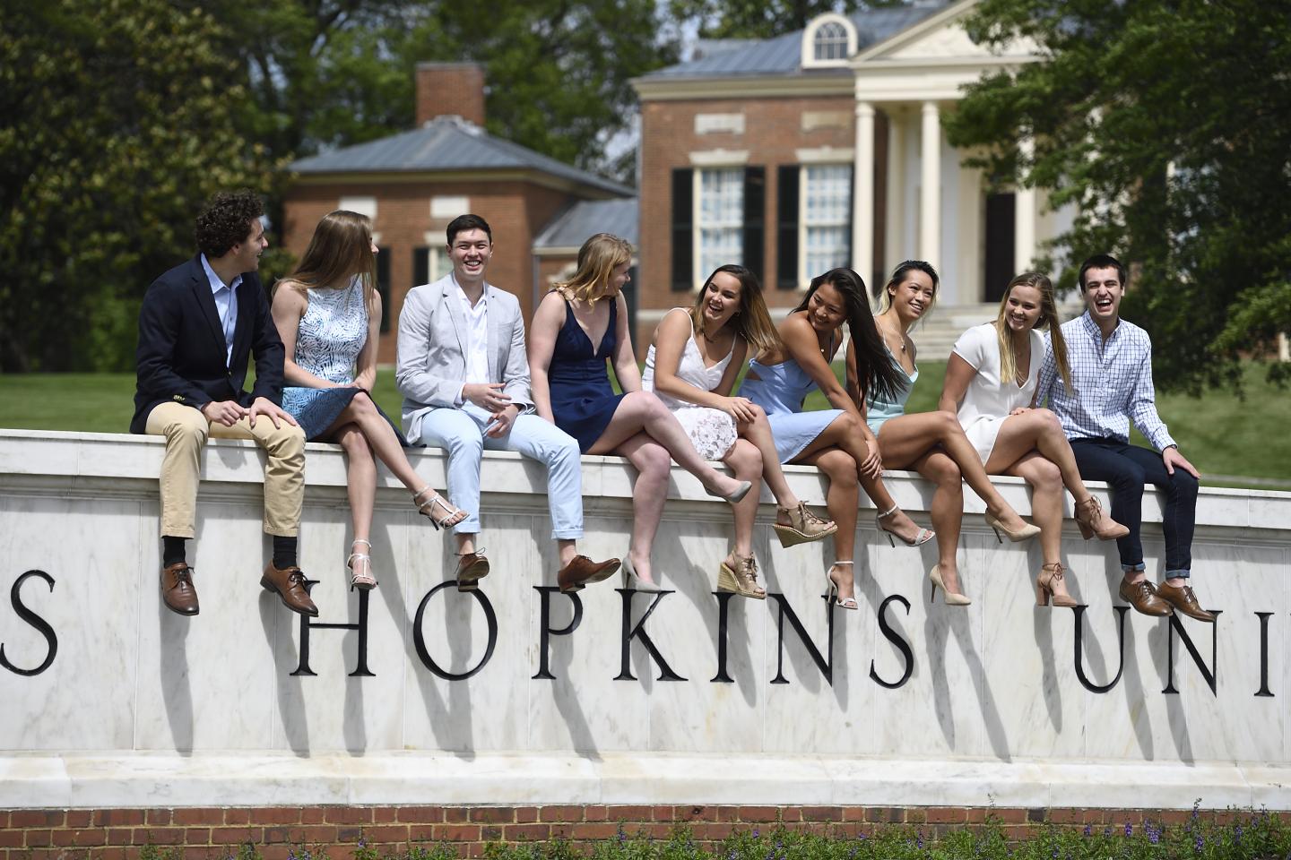 Seniors pose on the Johns Hopkins wall sign