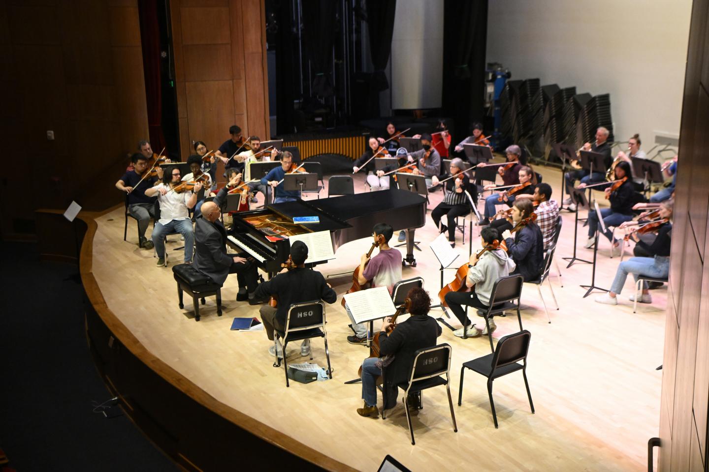 Jed Gaylin rehearses with the HSO while sitting at a grand piano