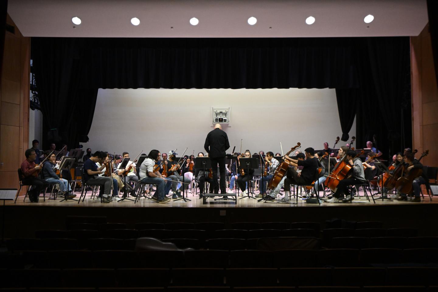 An image that shows a wide view of the Shriver Hall Auditorium stage where the HSO is practicing