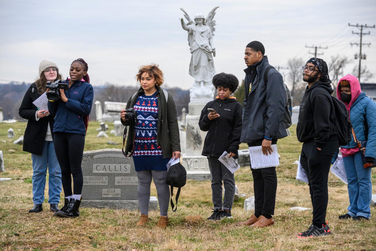 Students examine a grave stone at Mount Auburn Cemetery in Baltimore