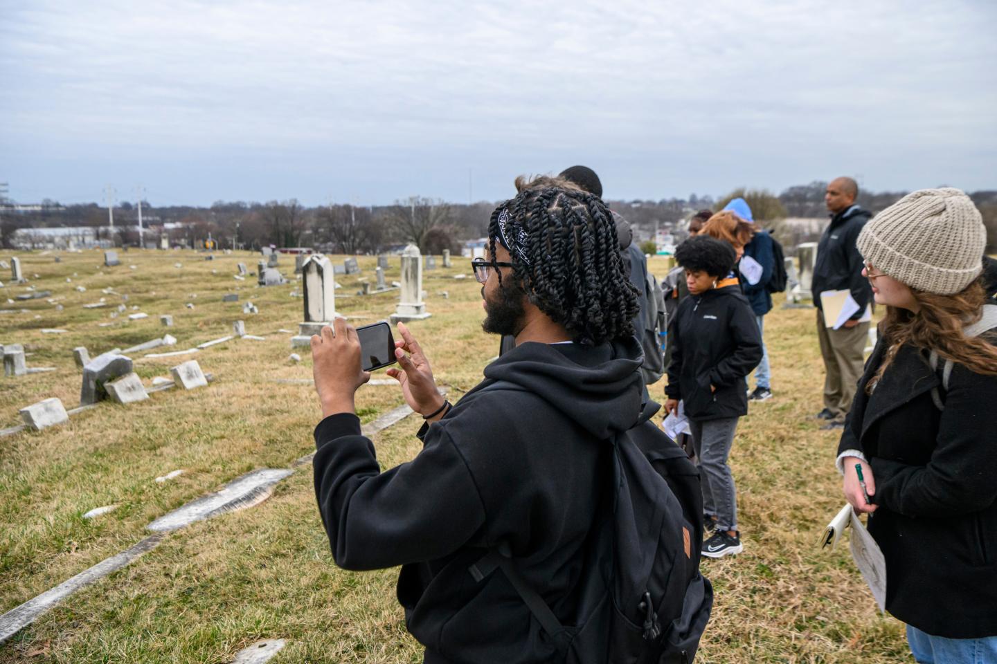 Students photograph a panoramic view of a cemetery